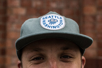 man wearing light blue raincloud corduroy snapback Seattle hat