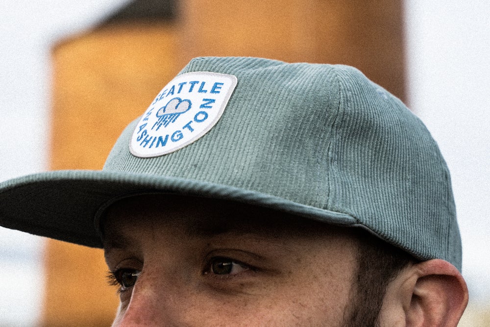 man wearing light blue raincloud corduroy snapback Seattle hat
