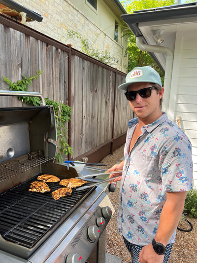 man barbecues while wearing alki supply light blue snapback corduroy hat