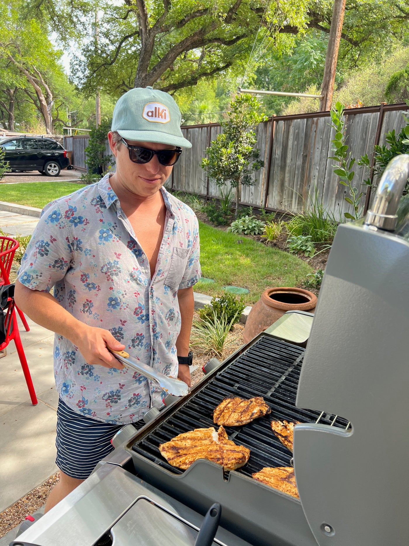 man barbecues while wearing alki supply light blue snapback corduroy hat